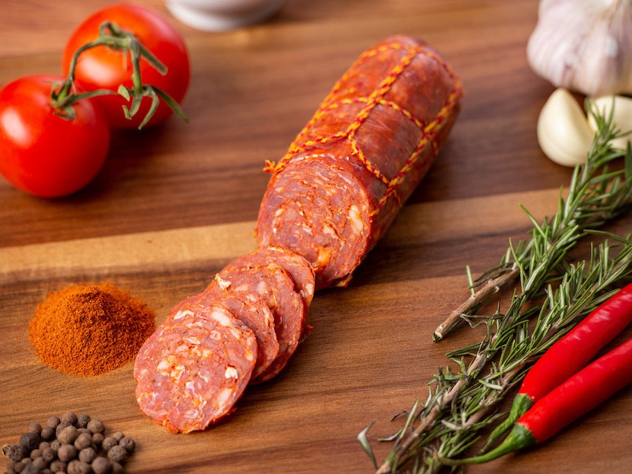 Italian Chorizo salami sliced on a timber board with smoked paprika