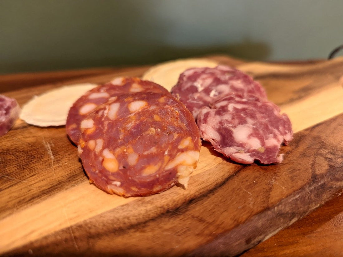 Sliced salami on a timber board in warm light