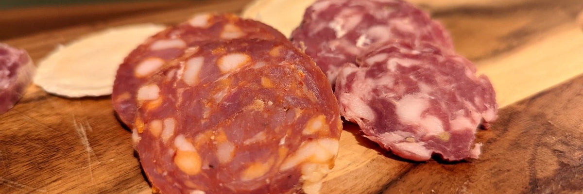 Sliced salami on a timber board in warm light
